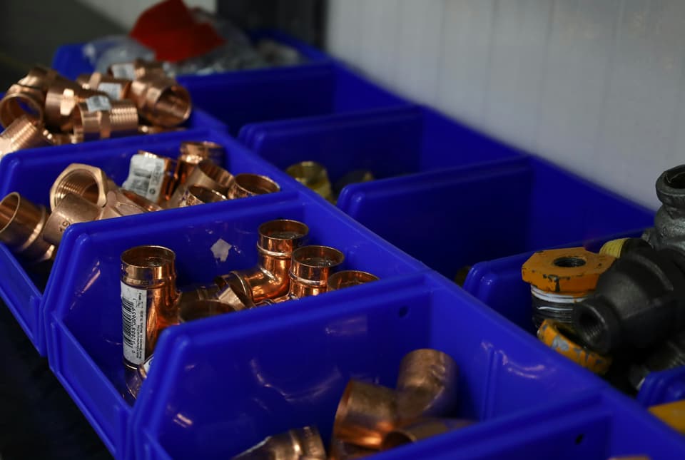 Copper pipe elbows and couplings sorted in blue parts bins
